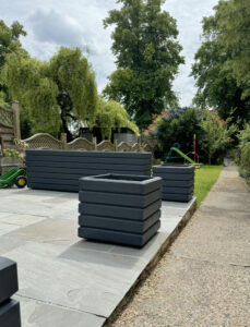 dark grey square planter in garden setting