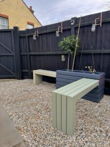 sage green wooden bench attached to a dark grey wooden planter