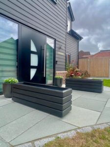 dark grey wooden planters on a light grey patio